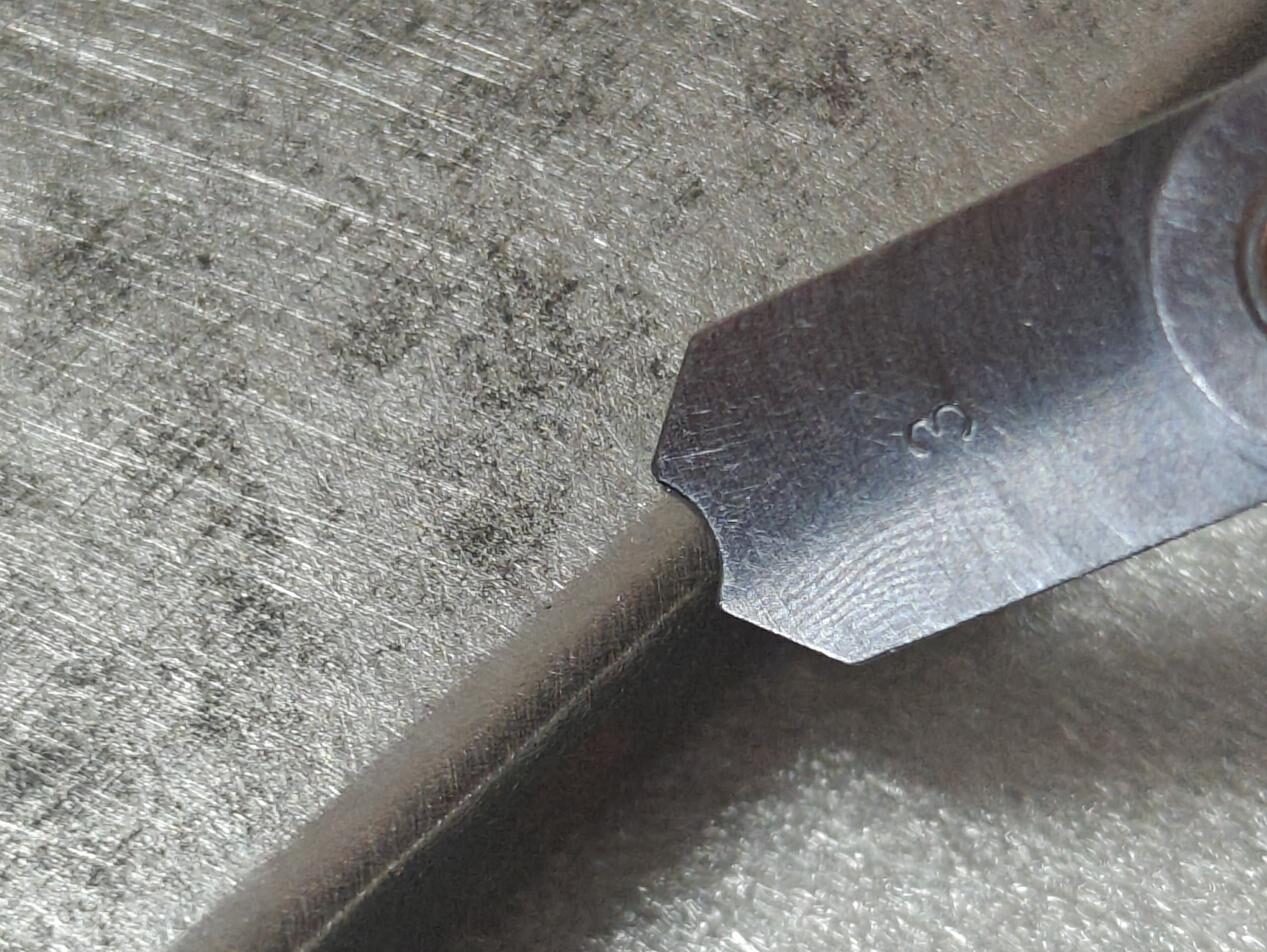 R3 edge rounding measurement on a stainless steel sheet using a radius gauge after precision edge rounding