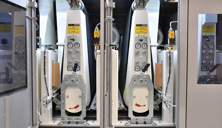 Internal view of twin wide belt grinding heads showing contact drums and pneumatic belt tensioners for chatter mark 